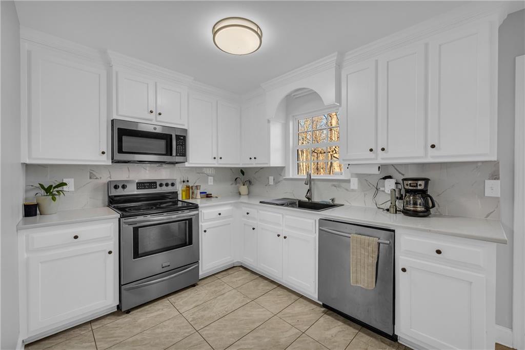3455 Navigator Lane Gainesville, GA 30507 - Photo 7 of 19 a kitchen with white cabinets stainless steel appliances and sink