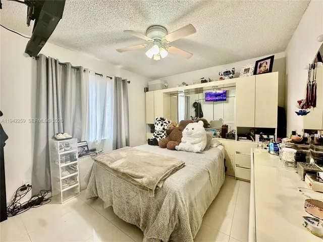 a spacious bedroom with a bed a couch and a chandelier