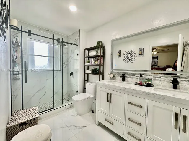 a spacious bathroom with a toilet a sink and shower