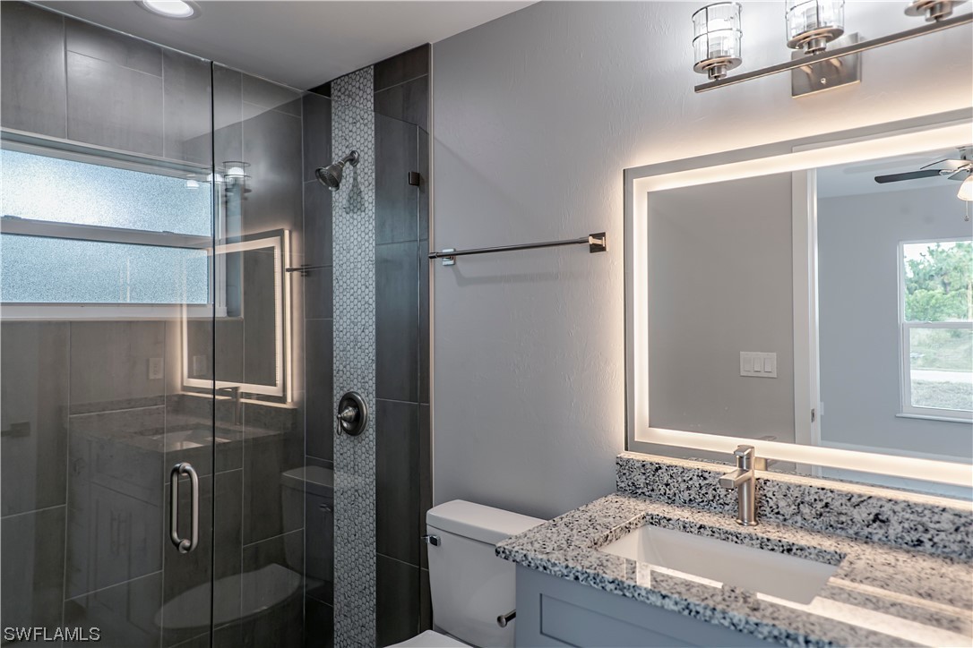 9035 West Crow Circle LaBelle, FL 33935 - Photo 20 of 32 a bathroom with a granite countertop shower sink and mirror