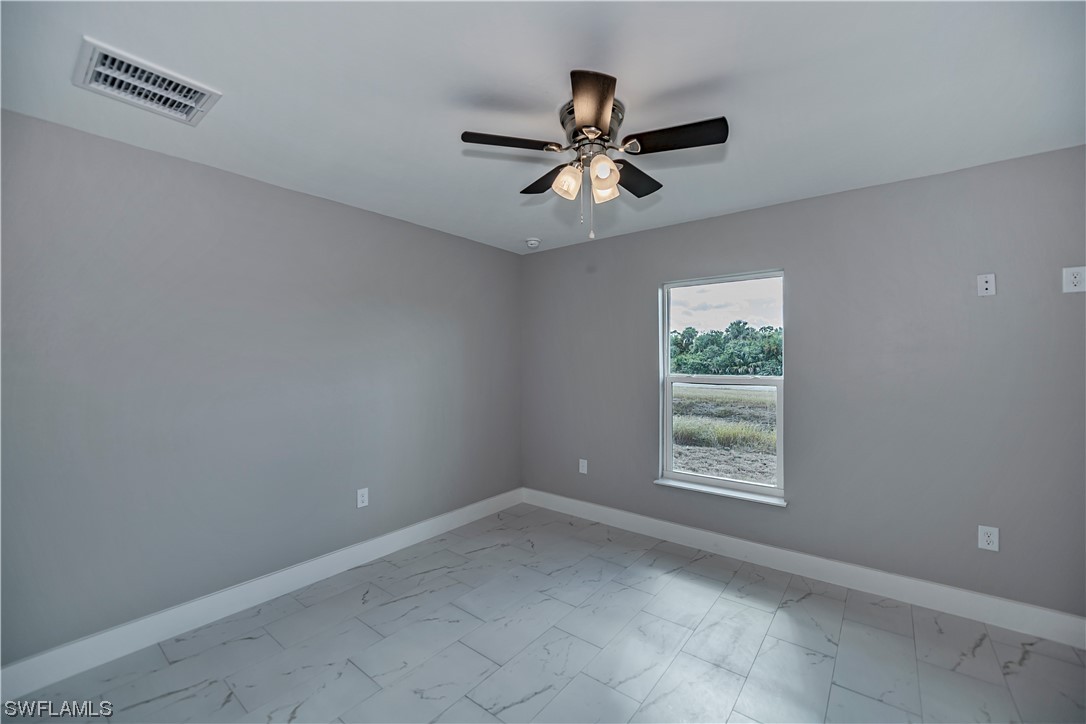 9035 West Crow Circle LaBelle, FL 33935 - Photo 25 of 32 an empty room with windows and fan