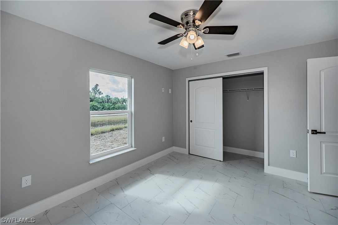 9035 West Crow Circle LaBelle, FL 33935 - Photo 26 of 32 an empty room with windows and fan
