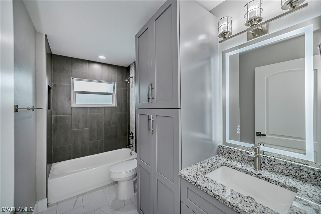 9035 West Crow Circle LaBelle, FL 33935 - Photo 27 of 32 a bathroom with a granite countertop sink toilet and shower