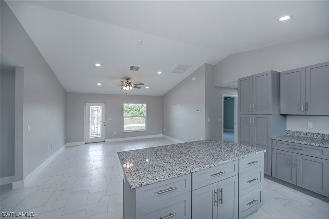 9035 West Crow Circle LaBelle, FL 33935 - Photo 7 of 32 a kitchen with granite countertop a sink and a stove