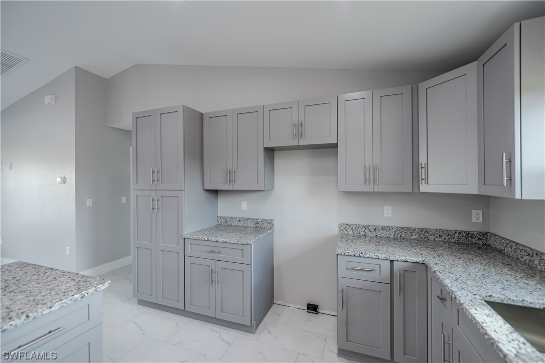 9035 West Crow Circle LaBelle, FL 33935 - Photo 10 of 32 a kitchen with cabinets appliances a sink and a counter top space