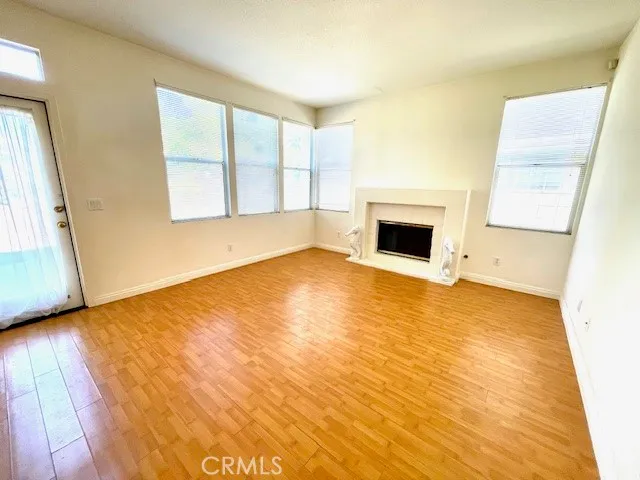 a view of empty room with wooden floor and fireplace