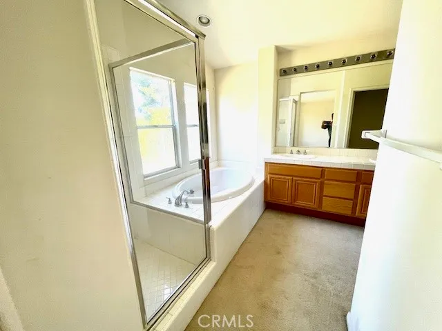 a bathroom with a tub sink and mirror