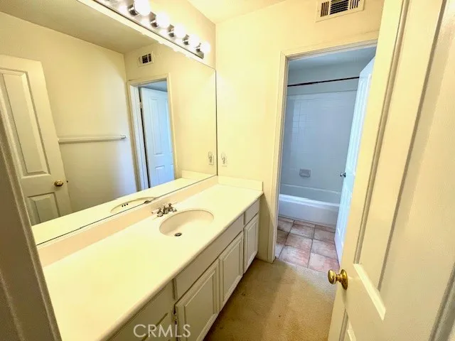 a bathroom with a tub sink and mirror