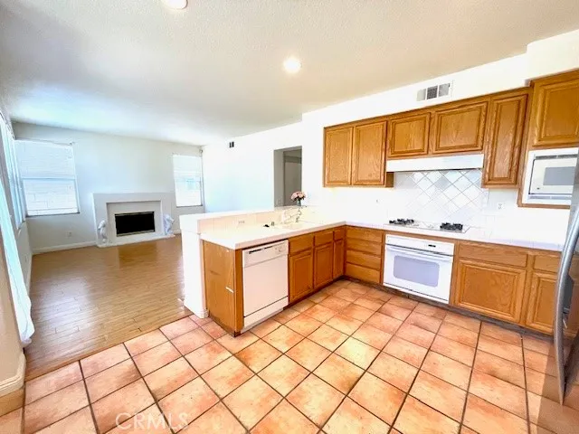 a kitchen with a sink a stove cabinets and wooden floor