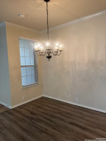 a view of a room with wooden floor cabinets and a chandelier