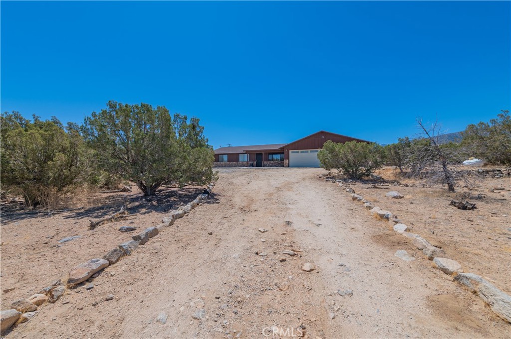 1181 Barkley Ranch Road Pinon Hills, CA 92372 - Photo 12 of 37 a view of dirt road with a building in the background