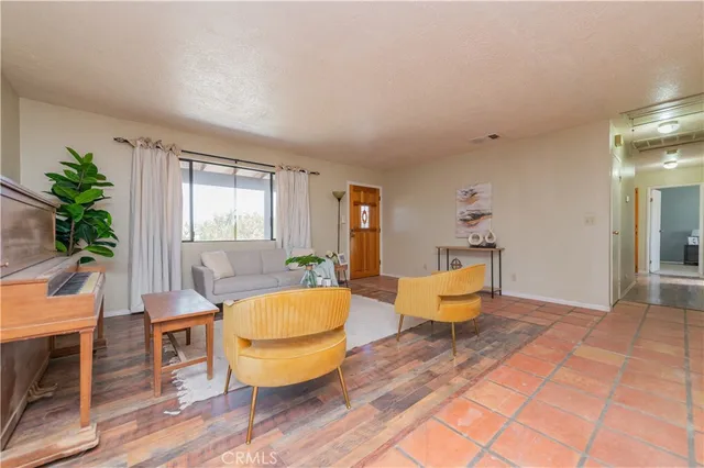 a living room with furniture a table and chair with wooden floor