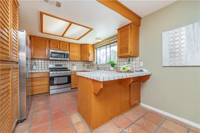 a kitchen with stainless steel appliances granite countertop a stove a sink dishwasher and a refrigerator