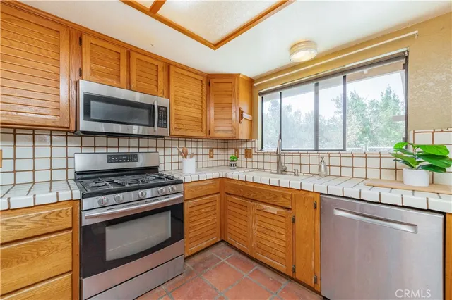 a kitchen with stainless steel appliances a stove sink and microwave