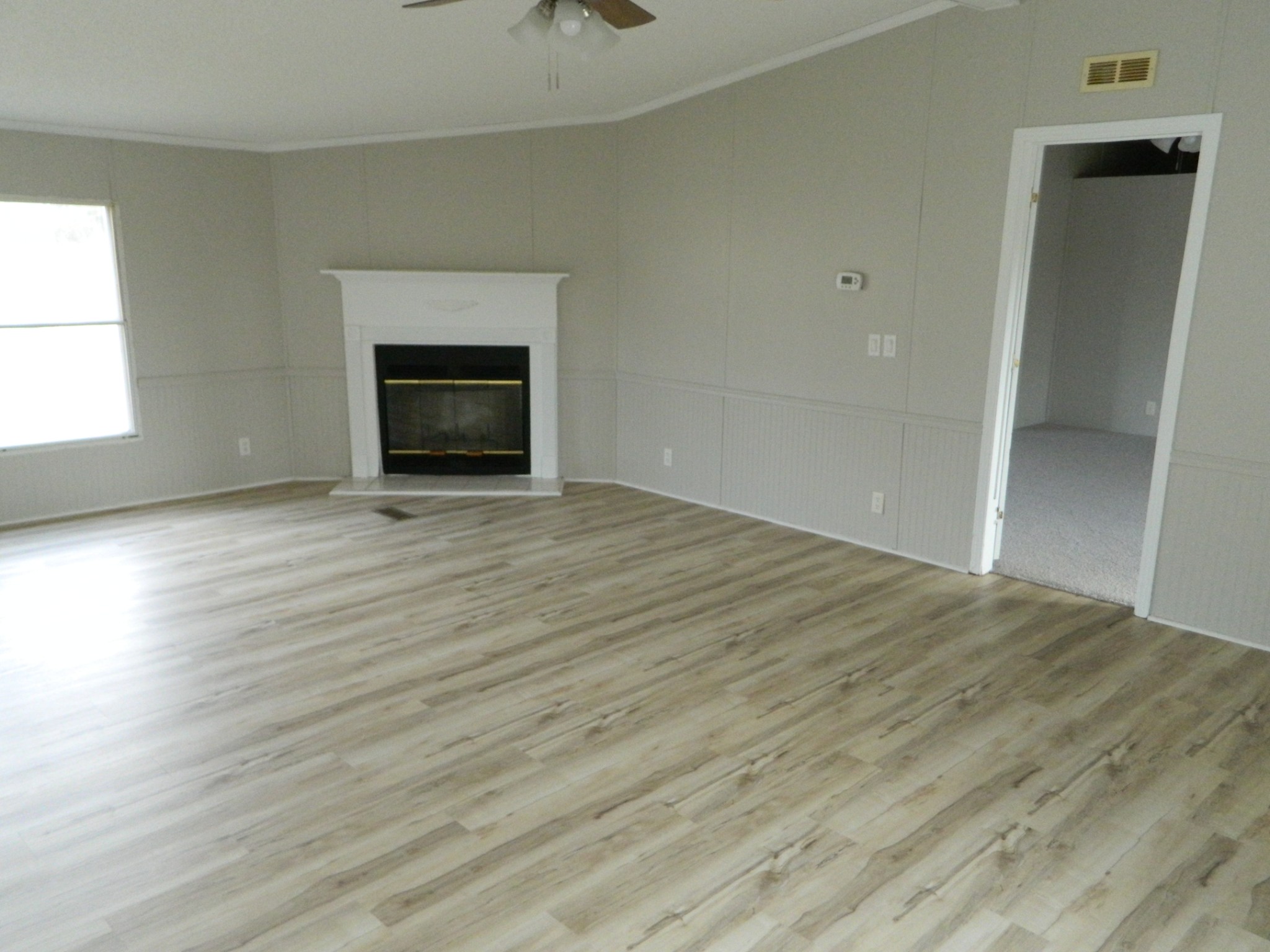 341 East Biggs Road Portland, TN 37148 - Photo 9 of 17 an empty room with wooden floor fireplace and windows