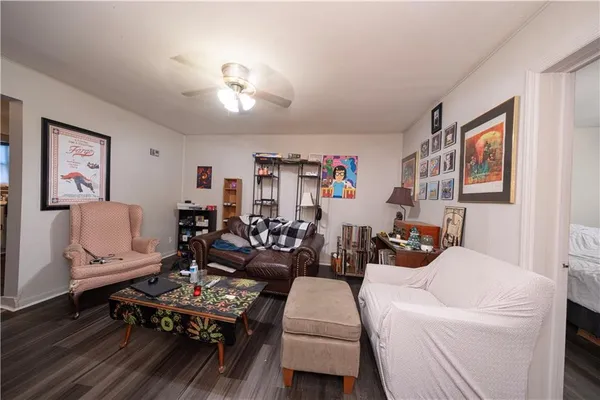 a living room with furniture a flat screen tv and a lamp