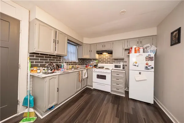 a kitchen with white cabinets and white appliances