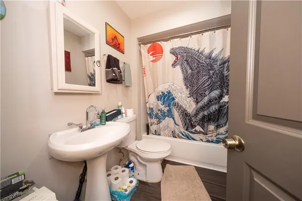 a bathroom with a toilet sink and mirror