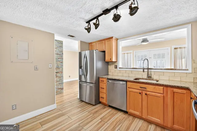 a kitchen with stainless steel appliances granite countertop a refrigerator and a sink