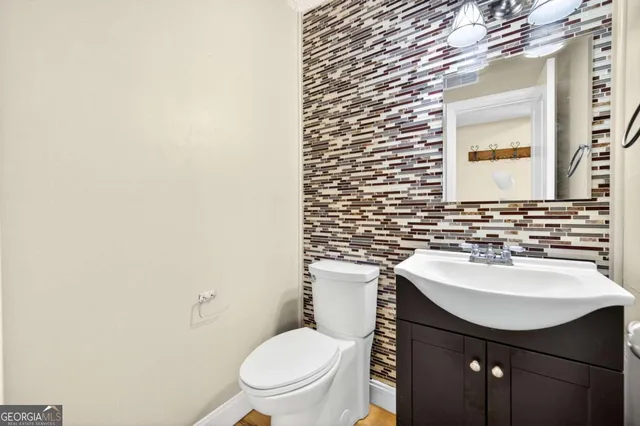 a bathroom with a sink a toilet and mirror