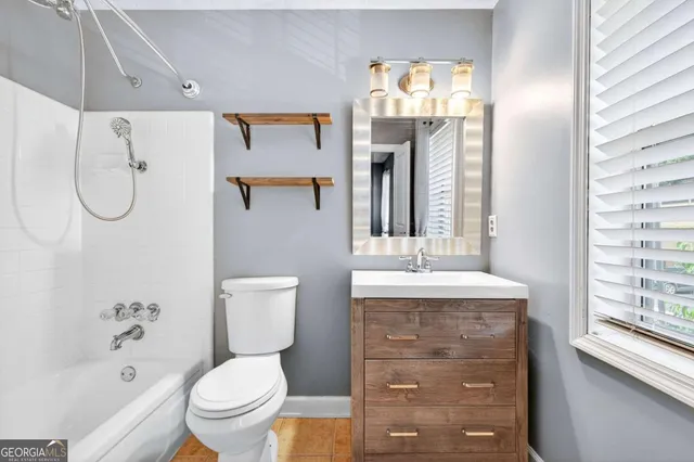 a bathroom with a granite countertop toilet sink and mirror