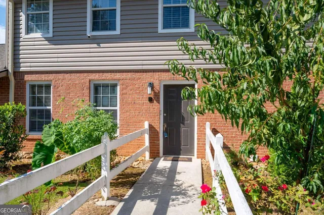 a view of a house with fountain and large trees