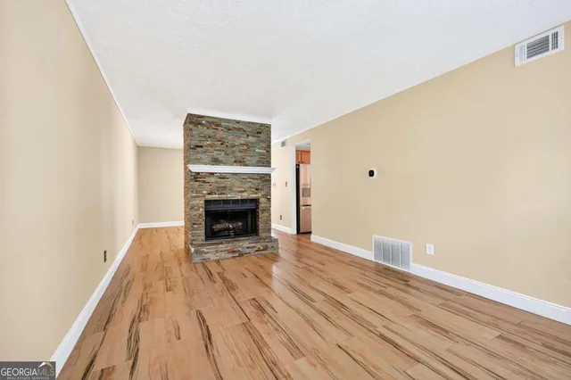 a view of a livingroom with wooden floor and a fireplace