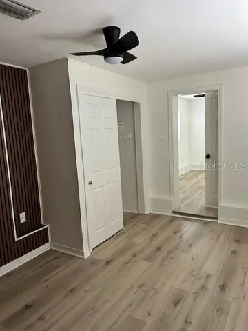 an empty room with wooden floor and closet