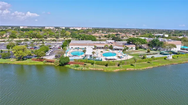 an aerial view of residential houses with outdoor space and lake view