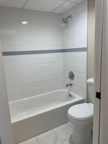 a bathroom with a white bath tub a toilet and a sink