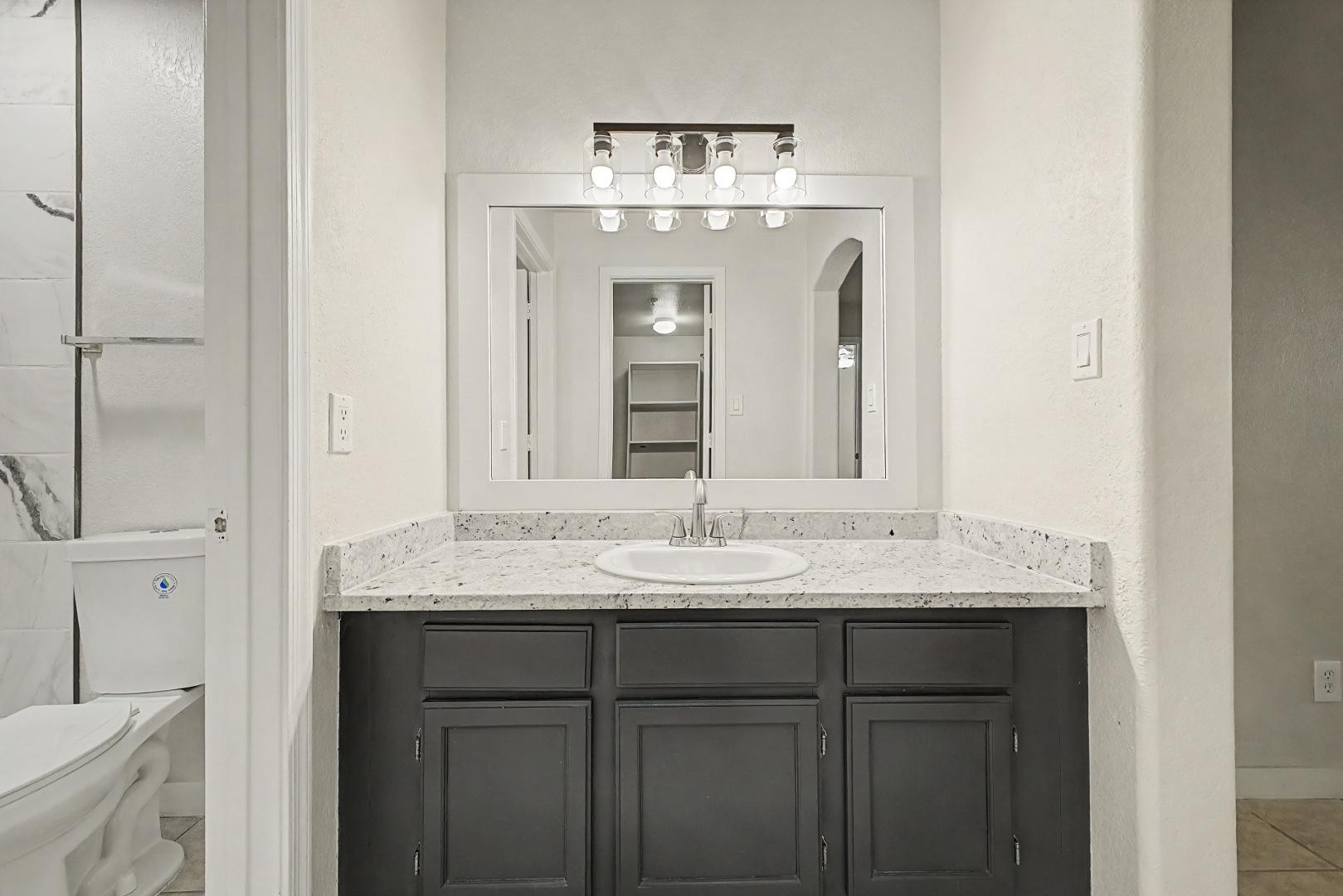 6885 East Cochise Road, Unit 142 Paradise Valley, AZ 85253 - Photo 27 of 47 a bathroom with a granite countertop sink a toilet and a mirror