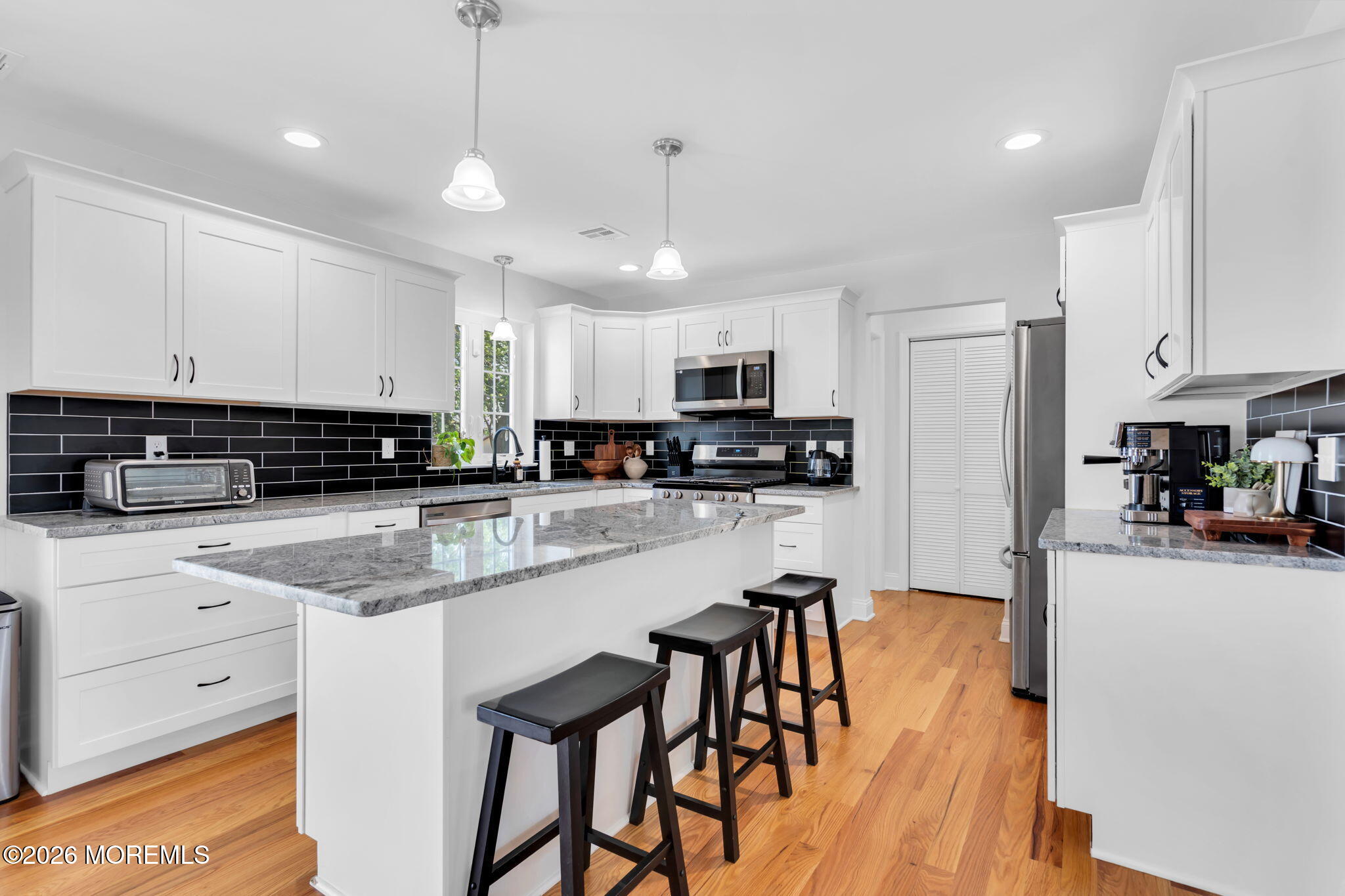 312 Beach Boulevard Forked River, NJ 08731 - Photo 19 of 40 a kitchen with stainless steel appliances granite countertop a stove top oven a refrigerator a sink and white cabinets