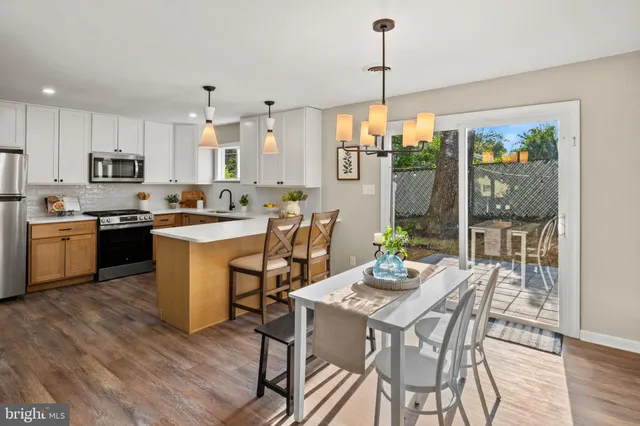 a view of a dining room and livingroom with furniture wooden floor a chandelier