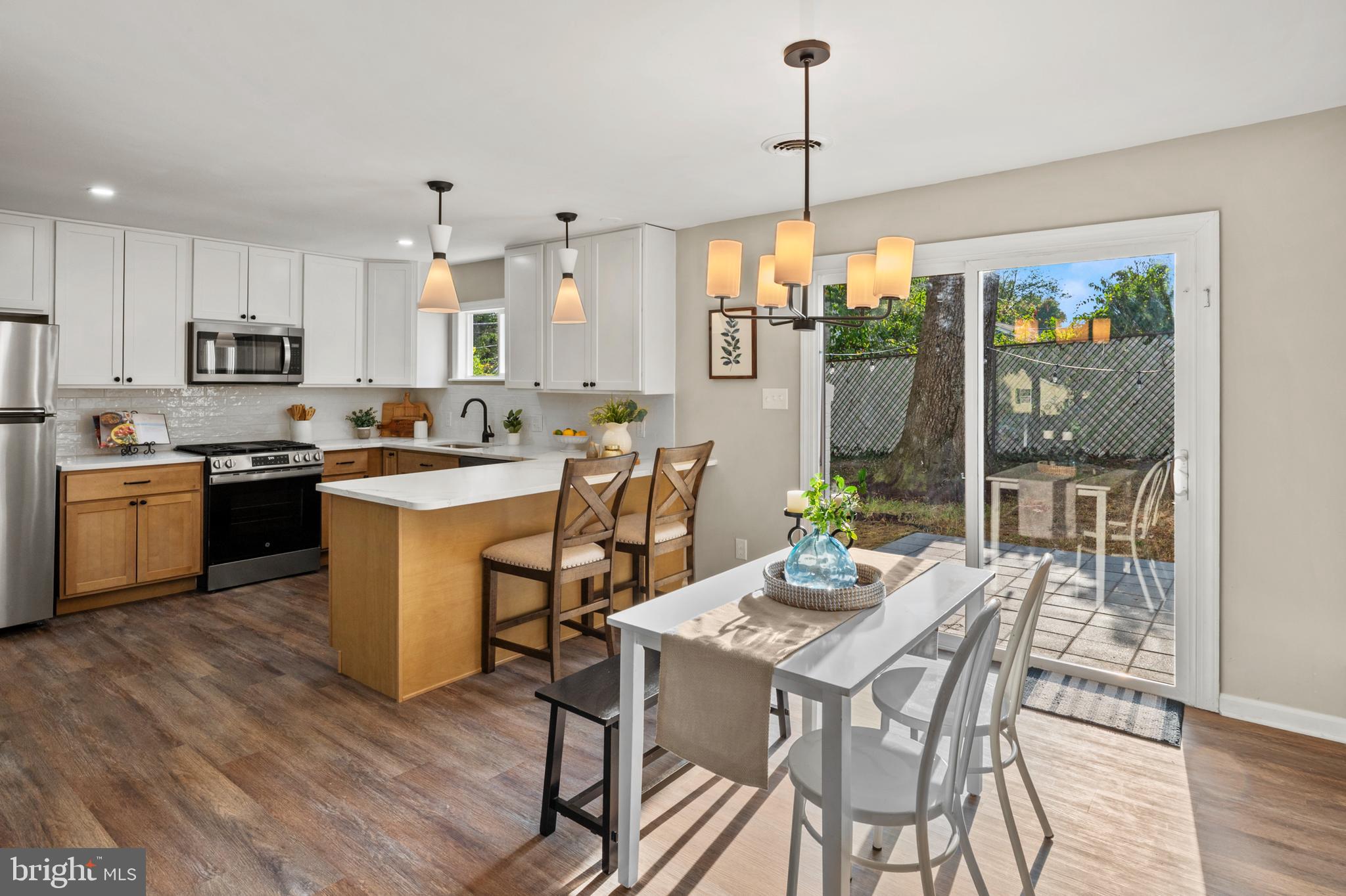 7966 Foster Avenue Severn, MD 21144 - Photo 3 of 25 a view of a dining room and livingroom with furniture wooden floor a chandelier