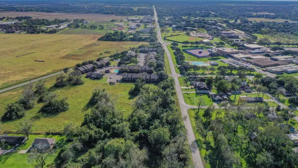 an aerial view of residential houses with outdoor space and lake view