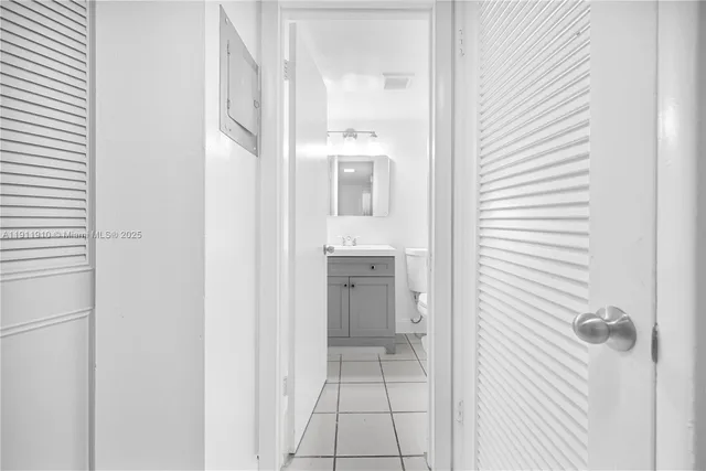 a view of a hallway with a white cabinet and a mirror