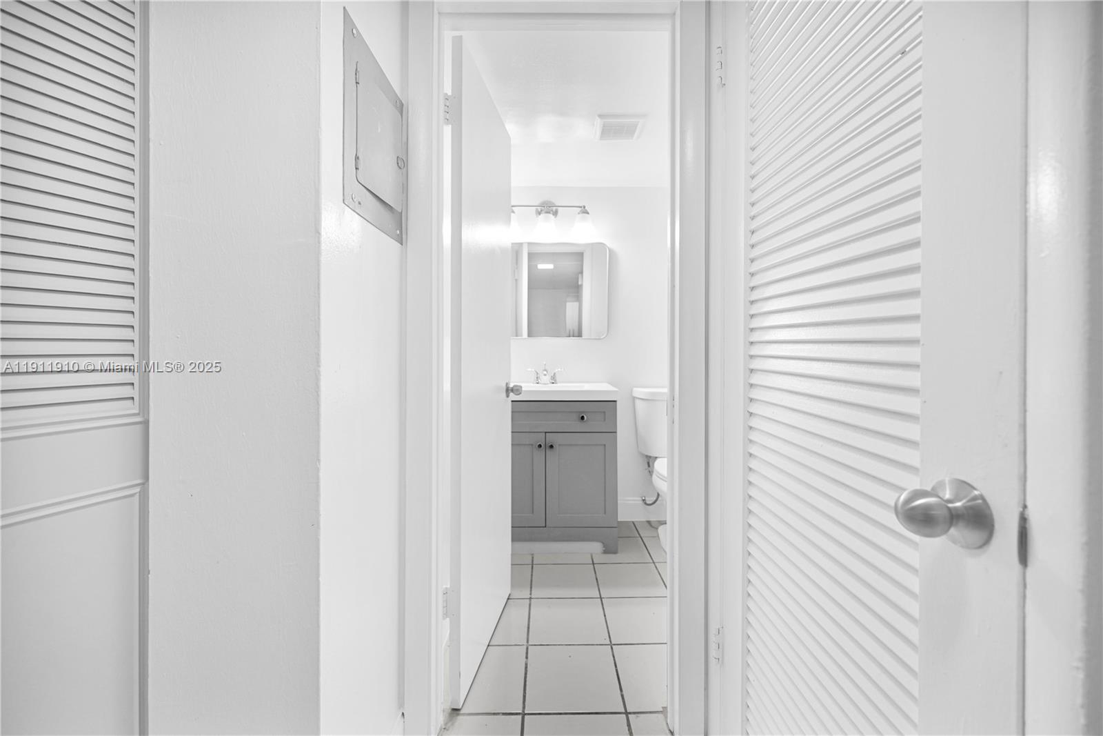 7550 Stirling Road, Unit C406 Davie, FL 33024 - Photo 16 of 27 a view of a hallway with a white cabinet and a mirror