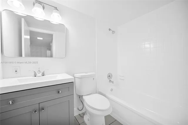 a bathroom with a toilet a sink a mirror and vanity