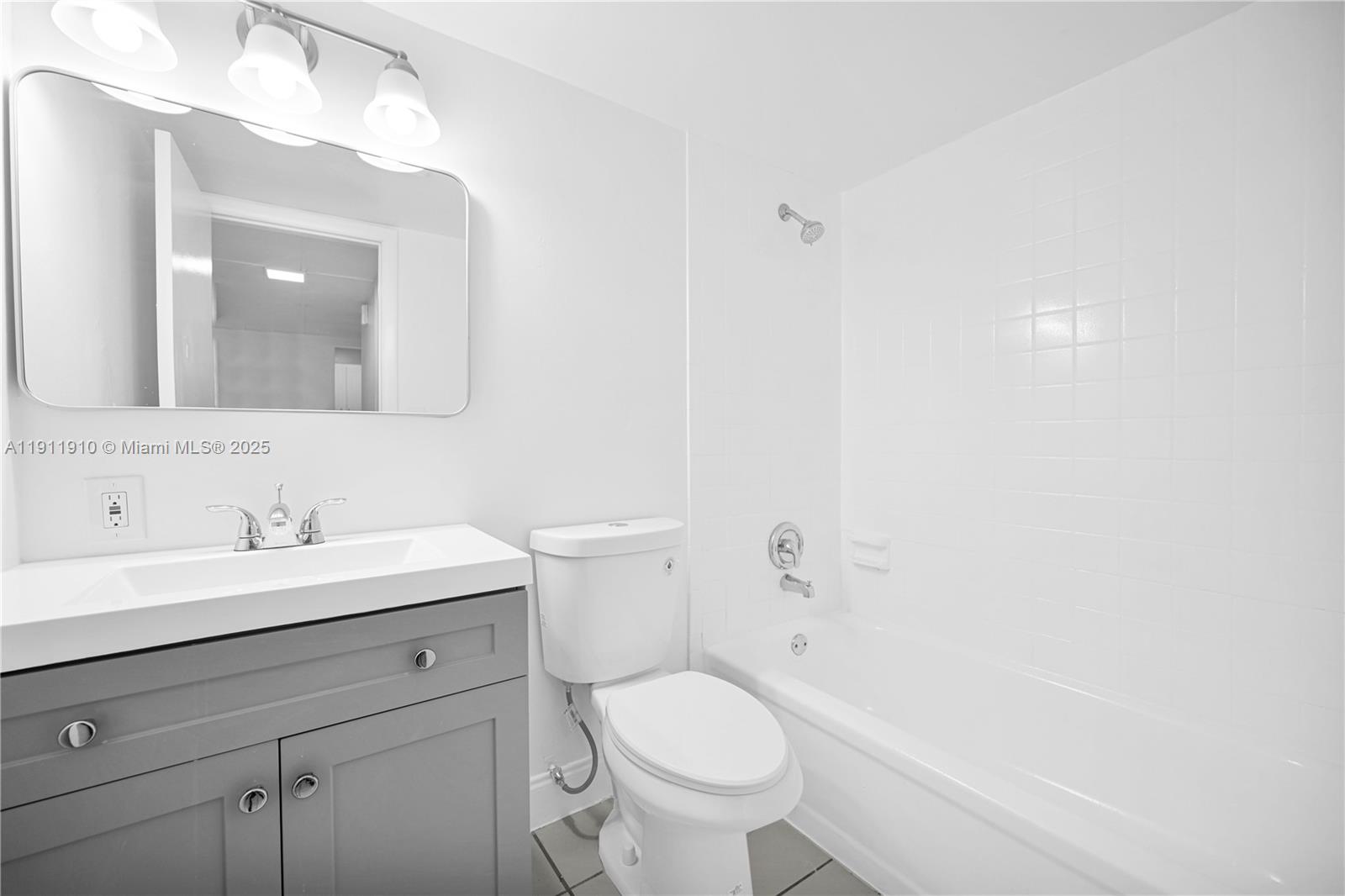 7550 Stirling Road, Unit C406 Davie, FL 33024 - Photo 19 of 27 a bathroom with a toilet a sink a mirror and vanity