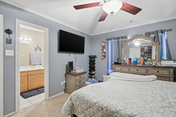 a spacious bedroom with a bed and a flat screen tv