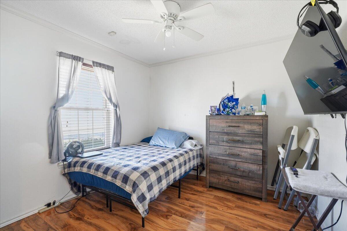 2101 76th Street Lubbock, TX 79423 - Photo 16 of 20 a bedroom with a bed and wooden floor