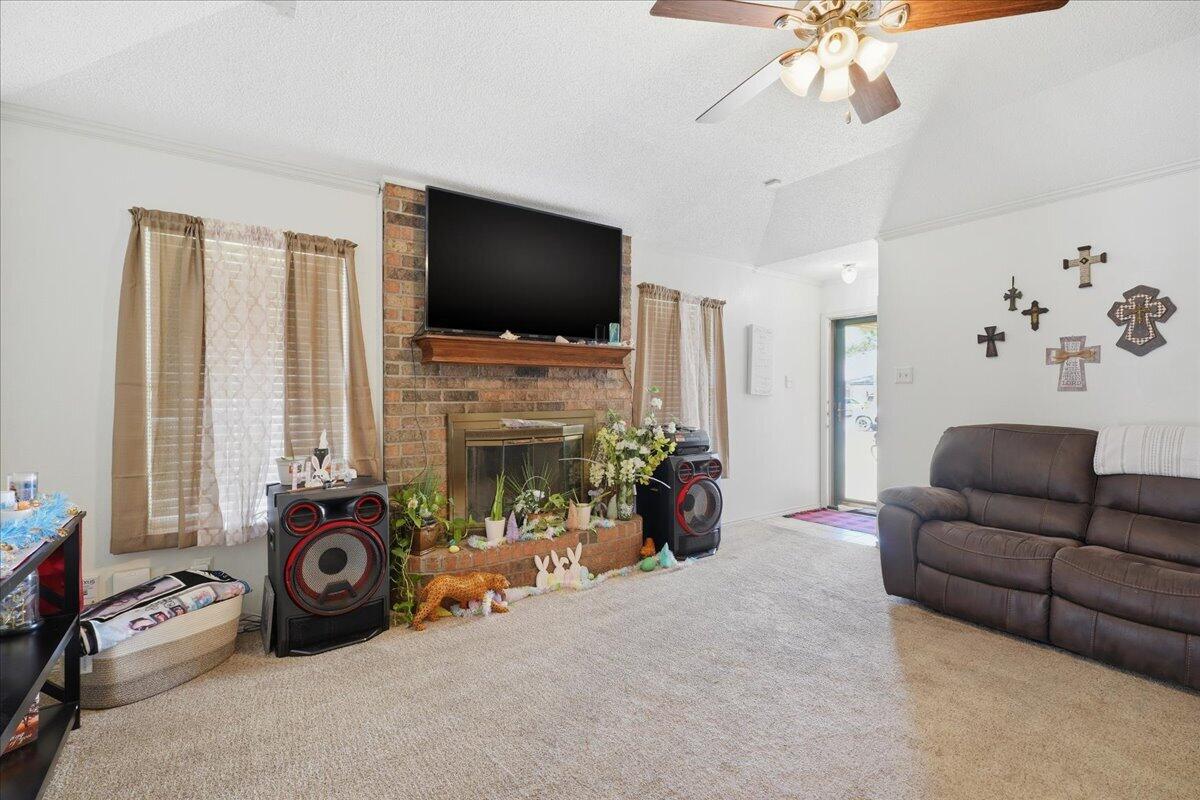 2101 76th Street Lubbock, TX 79423 - Photo 3 of 20 a living room with furniture a flat screen tv and a fireplace
