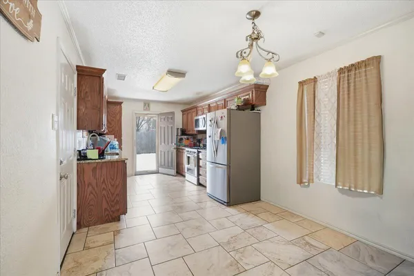 a view of a kitchen with furniture and a refrigerator