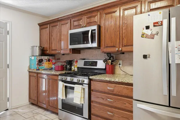 a kitchen with stainless steel appliances granite countertop a stove and a microwave
