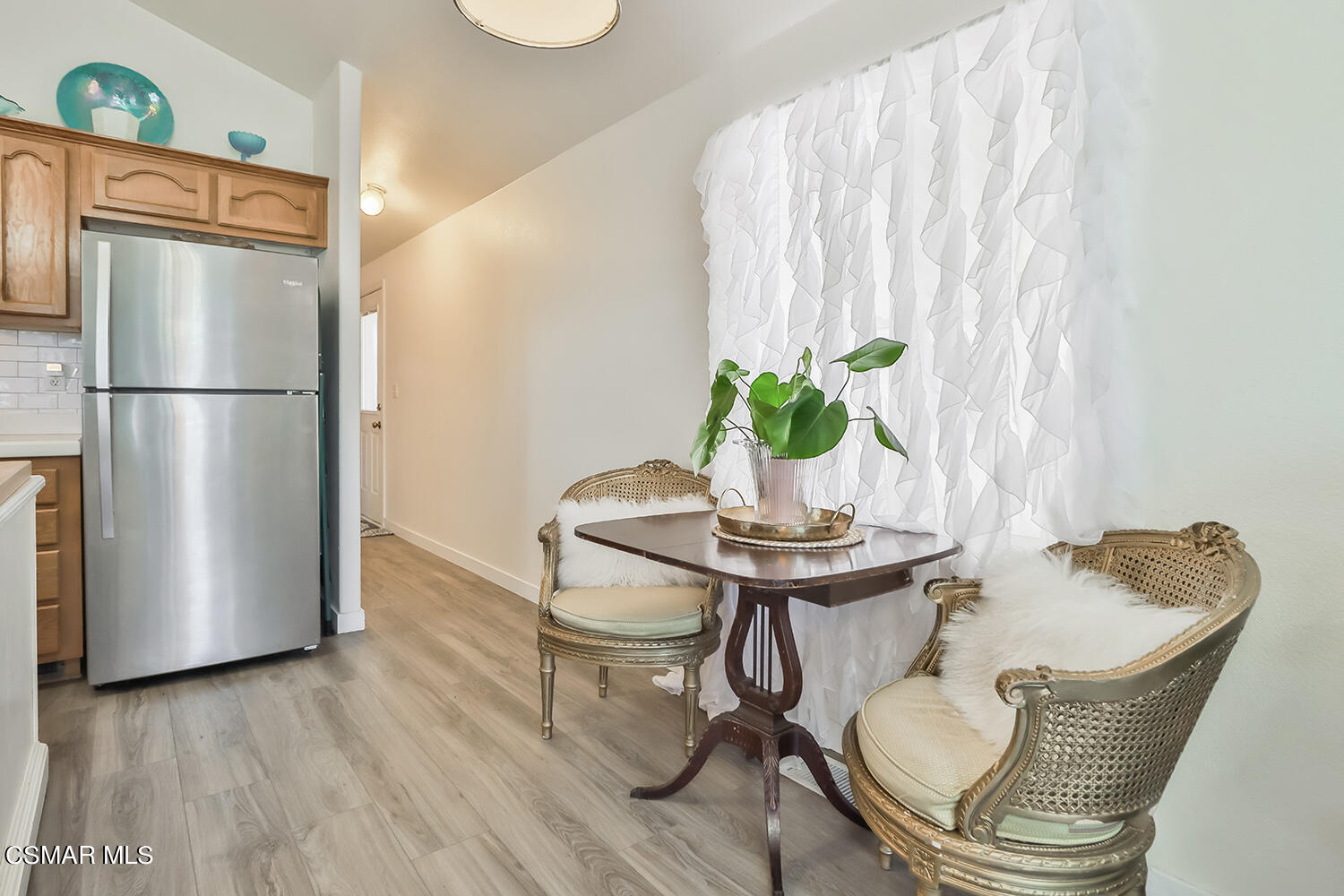 2168 Thrush Avenue, Unit 2168J Oxnard, CA 93033 - Photo 16 of 37 a dining room with furniture potted plants and wooden floor