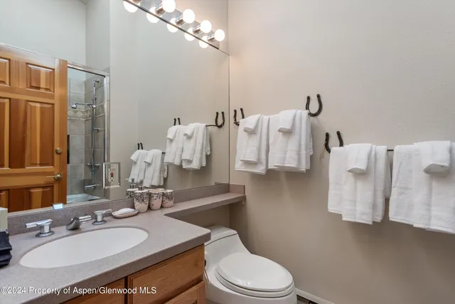 a bathroom with a granite countertop sink a toilet and a mirror