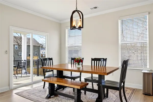 a living room with furniture kitchen view and a wooden floor