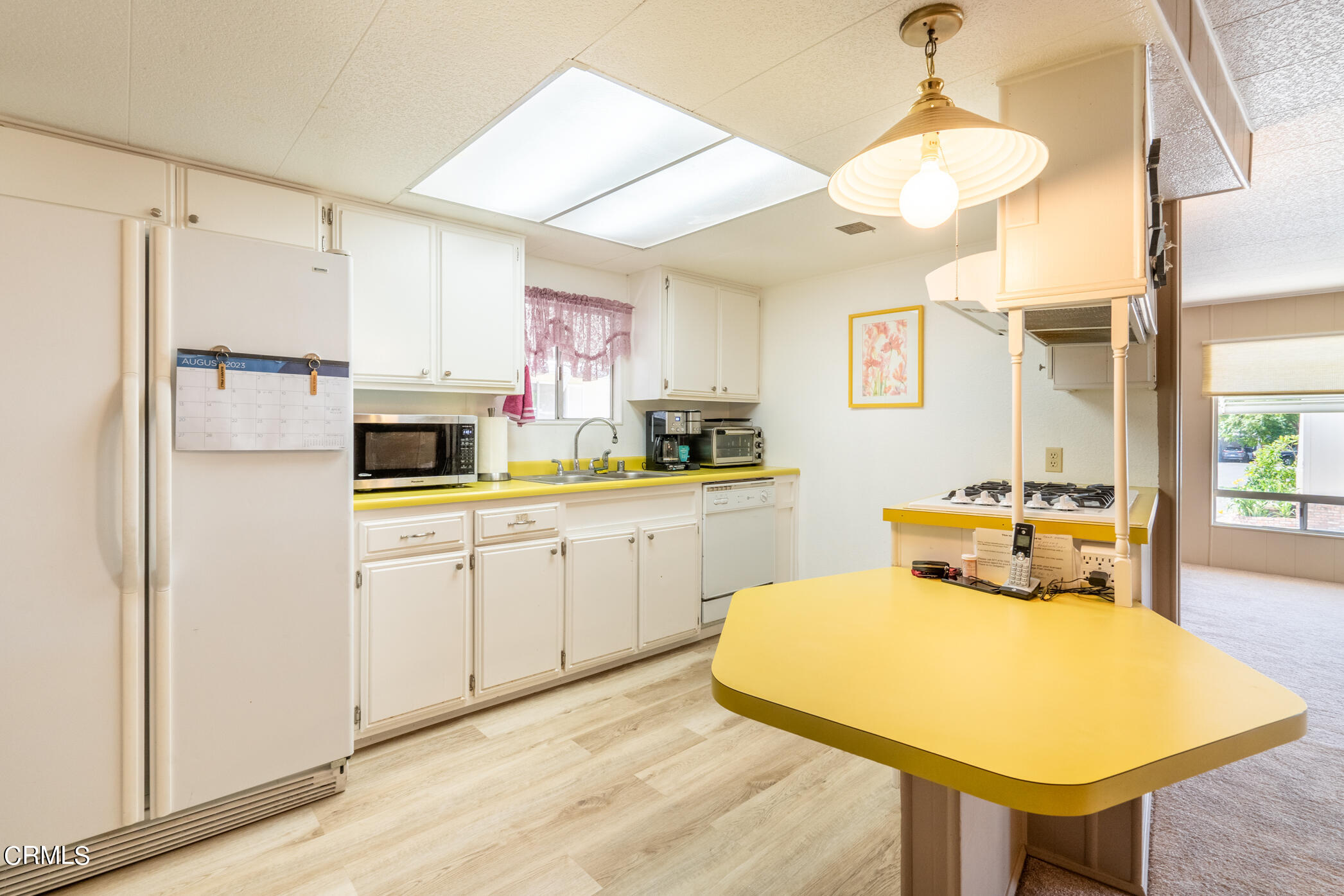 1225 South Rice Road, Unit 63 Ojai, CA 93023 - Photo 8 of 23 a kitchen with stainless steel appliances white cabinets and wooden floor