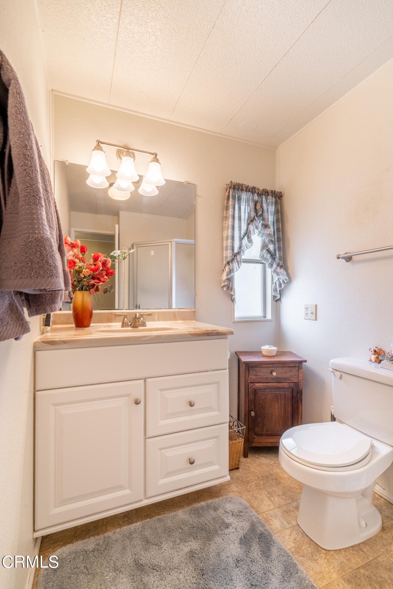 1225 South Rice Road, Unit 63 Ojai, CA 93023 - Photo 9 of 23 a bathroom with a granite countertop toilet sink and mirror