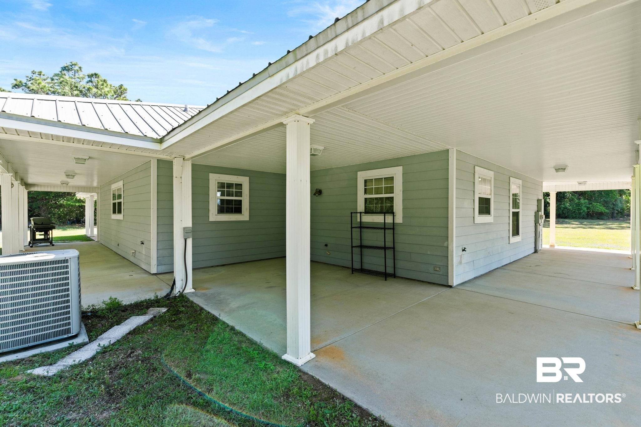 20219 Greek Cemetery Road Robertsdale, AL 36567 - Photo 34 of 41 Expansive covered concrete patio with white columns and a metal roof